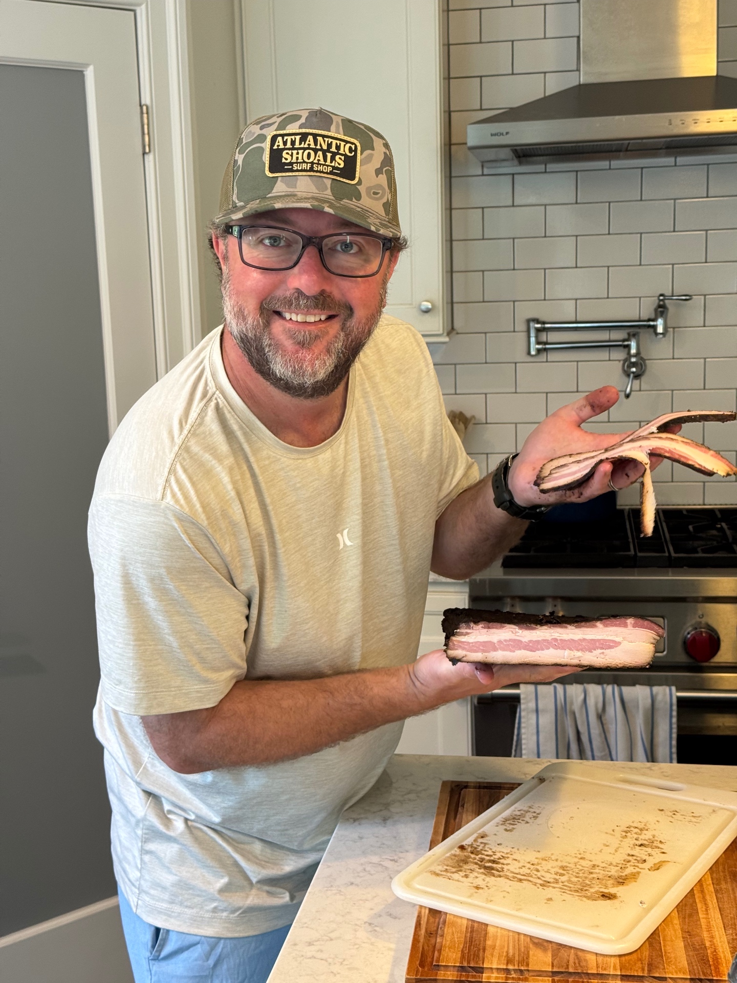 Holding the finished smoked bacon slab, showing the dark cured exterior and pink cross-section