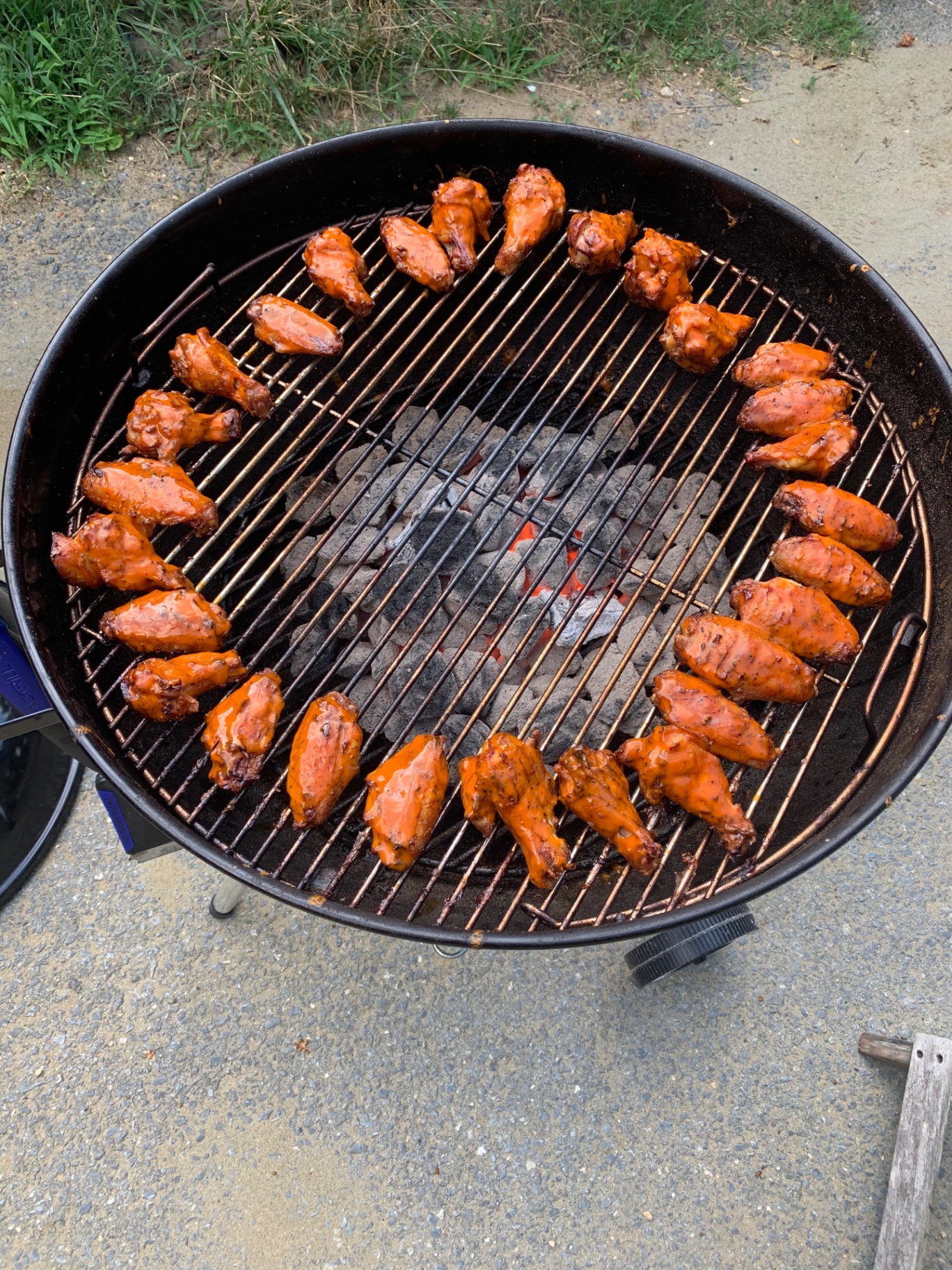 Chicken wings coated in buffalo sauce on the grill