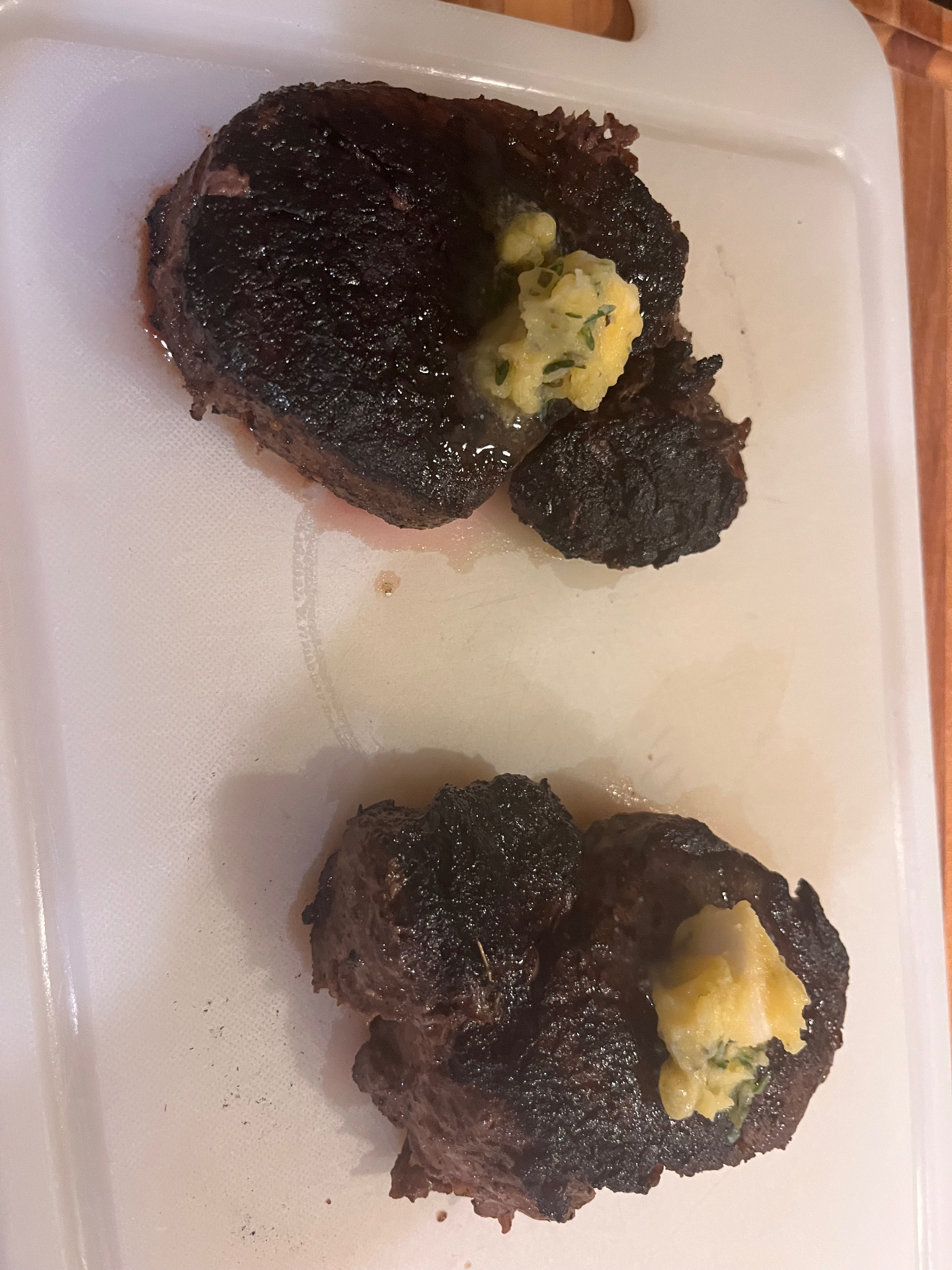 Two seared filets resting with herb butter melting on top